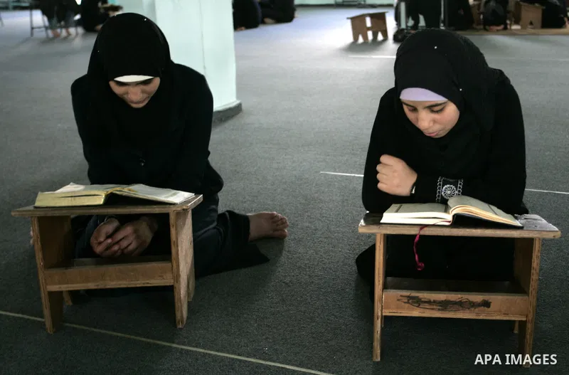 Two Palestinian girls read the Koran at a summer camp for the study of Islam's holy book organised by the Islamist movement Hamas in Rafah in the southern of Gaza Strip on June 19, 2011. Photo by Abed Rahim Khatib