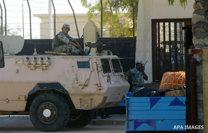 Egyptian soldiers stand guard while the Palestinians wait to cross into Egypt through the Rafah border crossing in the southern Gaza Strip on June 20, 2011. Photo by Abed Rahim Khatib