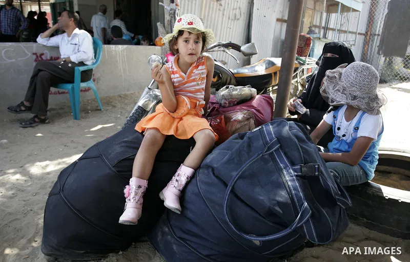 A Palestinian girl with her family wait to cross into Egypt through the Rafah border crossing in the southern Gaza Strip on June 20, 2011. Photo by Abed Rahim Khatib