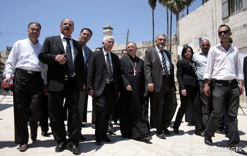 The head of the Roman Catholic Church in the Holy Land, the Latin Patriarch of Jerusalem Fuad Twal walks among Palestinian officials near the Ibrahimi Mosque, or Tomb of the Patriarchs, during a visit to the divided West...