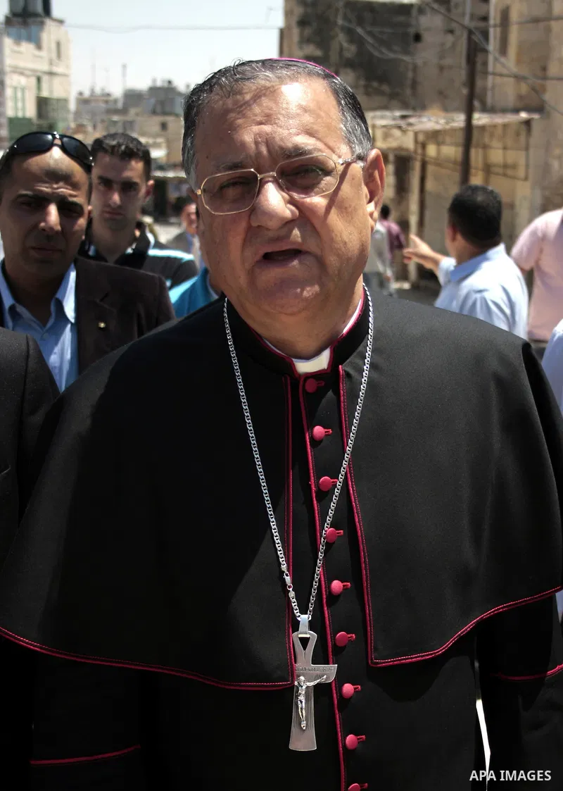 The head of the Roman Catholic Church in the Holy Land, the Latin Patriarch of Jerusalem Fuad Twal walks among Palestinian officials near the Ibrahimi Mosque, or Tomb of the Patriarchs, during a visit to the divided West...