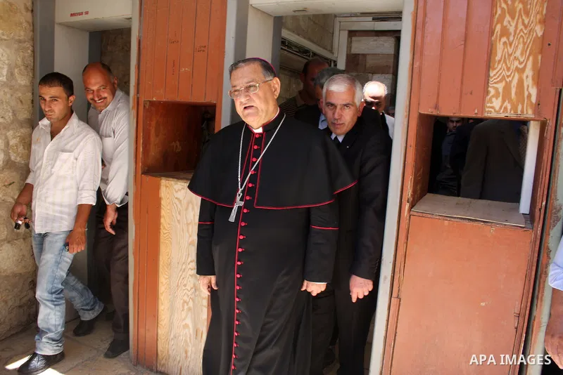 The head of the Roman Catholic Church in the Holy Land, the Latin Patriarch of Jerusalem Fuad Twal walks among Palestinian officials near the Ibrahimi Mosque, or Tomb of the Patriarchs, during a visit to the divided West...