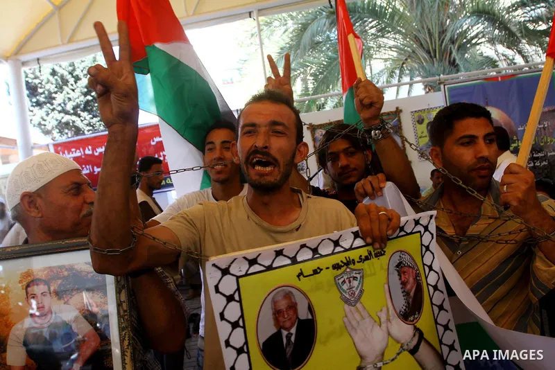 Palestinians hold pictures of their jailed relatives during a protest outside the Red Cross' offices in Gaza City calling for the release of Palestinian prisoners held in Israeli jails, on June 20, 2011. Photo by Ashraf...