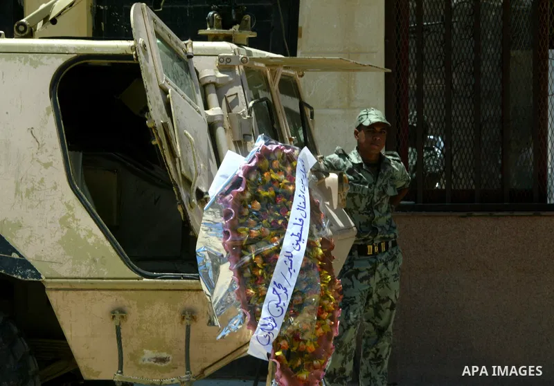 An Egyptian soldier stands next a wreath which laid by Palestinian children during a rally in front of the Rafah border crossing with Egypt in the southern Gaza Strip on June 21, 2011, demanding it to be open permanently...