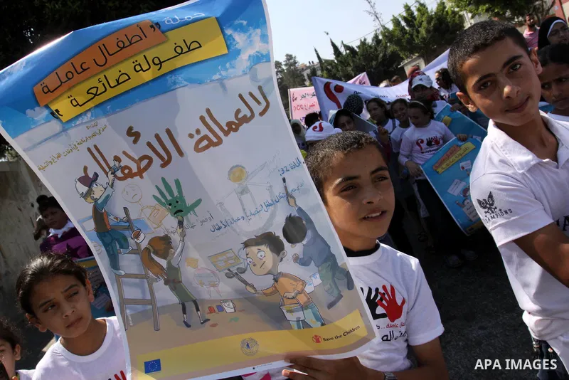 Palestinian children hold up signs during a protest against child labor in Gaza city on June 22, 2011. this protest under the auspices of Save the Children and heading to the Ministry of Labour. Photo by Mohammed Asad