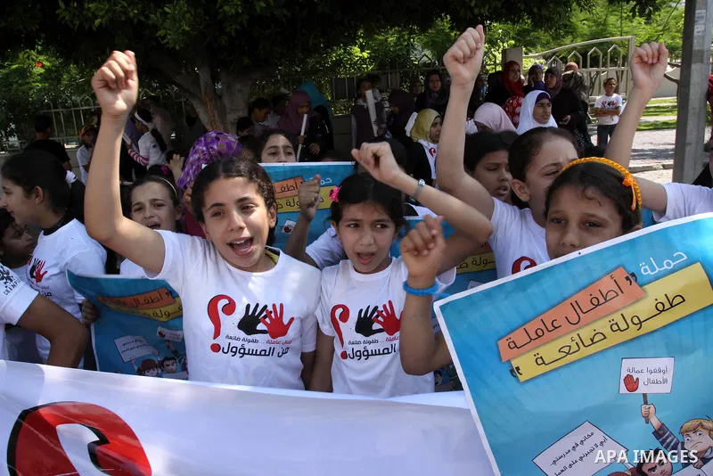 Palestinian children hold up signs during a protest against child labor in Gaza city on June 22, 2011. this protest under the auspices of Save the Children and heading to the Ministry of Labour. Photo by Mohammed Asad