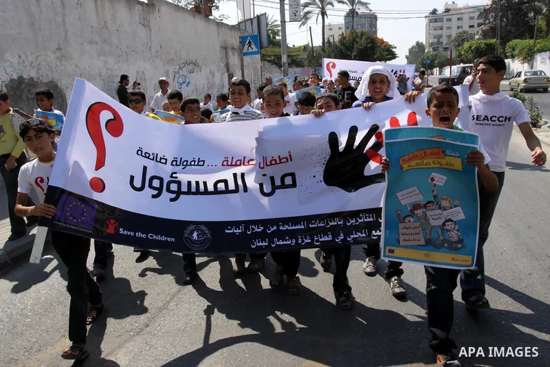 Palestinian children hold up signs during a protest against child labor in Gaza city on June 22, 2011. this protest under the auspices of Save the Children and heading to the Ministry of Labour. Photo by Mohammed Asad