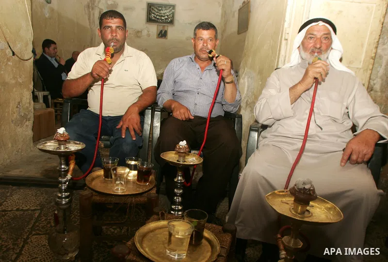 Palestinian men smoke waterpipes at a cafe in Jerusalem's old city on Jun 22,2011. Photo by Mahfouz Abu Turk