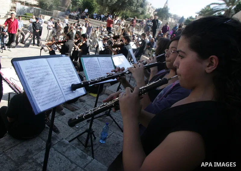 Palestinians and foreigners play the violin in front of the Damascus Gate in Jerusalem's old city on Jun 22,2011. Photo by Mahfouz Abu Turk