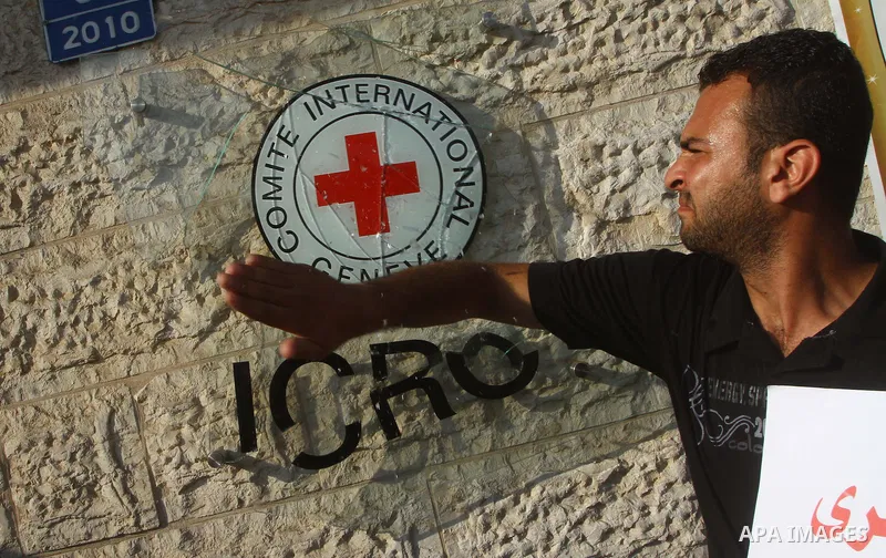 A Palestinian man breaks the glass sign of the International Committee of the Red Cross (ICRC) as dozens of angry protesters demonstrated outside the premises of the ICRC in Gaza City on June 23, 2011 against a call for...