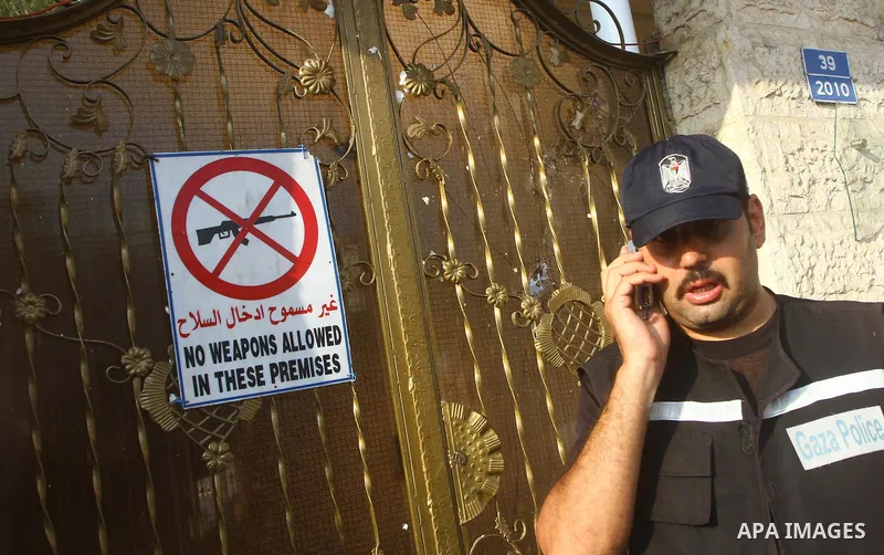A Palestinian policeman guards outside the building housing the offices of the International Committee of the Red Cross (ICRC) as dozens of angry protesters demonstrated outside the premises of the ICRC in Gaza City on J...