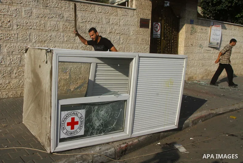 A Palestinian man destroys the guard post outside the building housing the offices of the International Committee of the Red Cross (ICRC) as dozens of angry protesters demonstrated outside the premises of the ICRC in Gaz...
