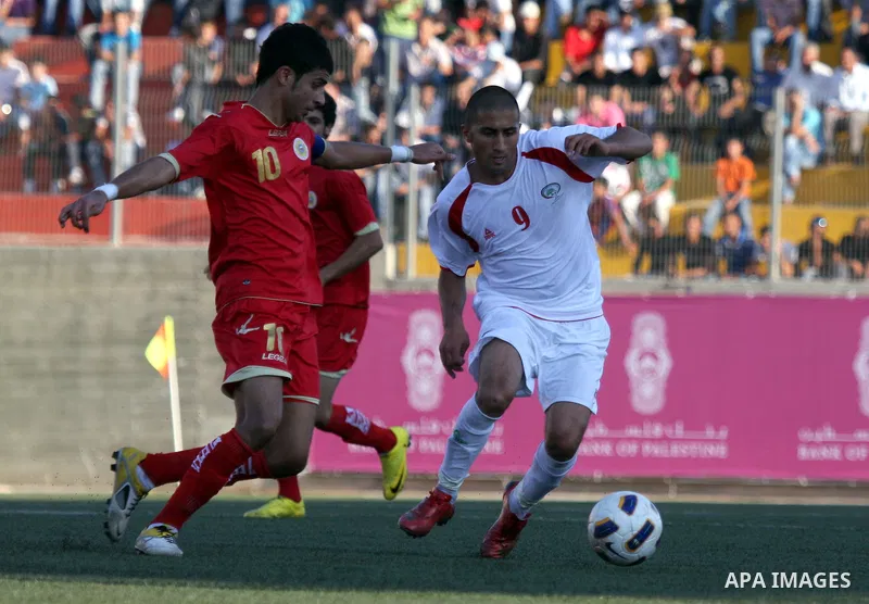Palestinian team's player challenges the Bahrain's player during their 2012 Olympic qualifying football match in the West Bank town of Al-Ram, near Ramallah, on June 23, 2011 . Photo by Issam Rimawi