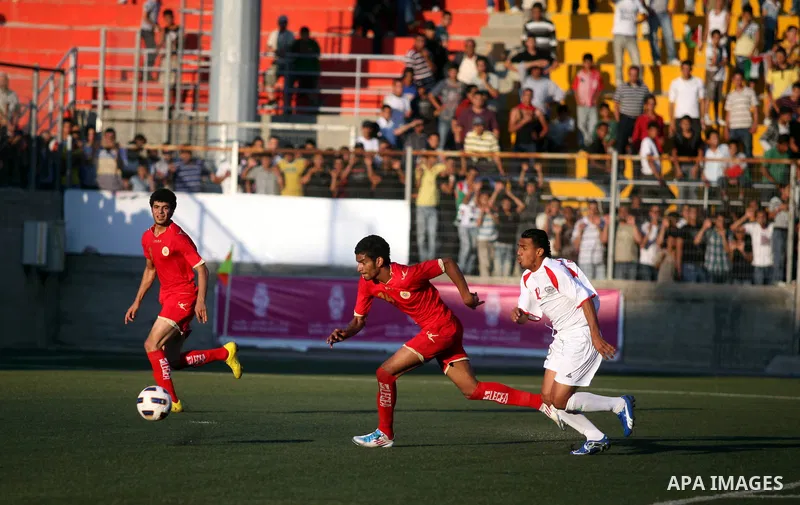Palestinian team's player challenges the Bahrain's player during their 2012 Olympic qualifying football match in the West Bank town of Al-Ram, near Ramallah, on June 23, 2011 . Photo by Issam Rimawi