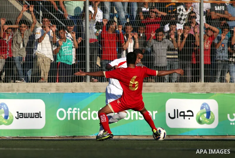 Palestinian team's player challenges the Bahrain's player during their 2012 Olympic qualifying football match in the West Bank town of Al-Ram, near Ramallah, on June 23, 2011 . Photo by Issam Rimawi