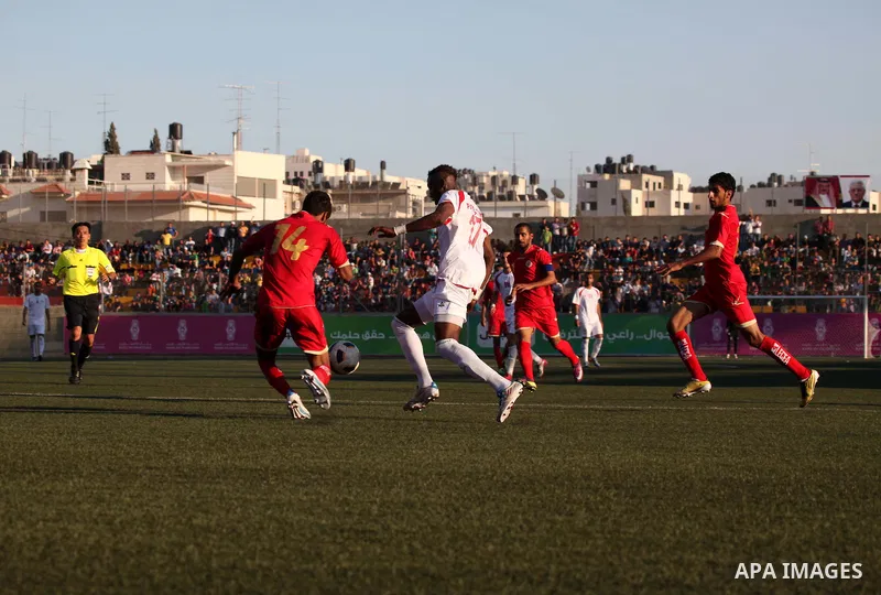 Palestinian team's player challenges the Bahrain's player during their 2012 Olympic qualifying football match in the West Bank town of Al-Ram, near Ramallah, on June 23, 2011 . Photo by Issam Rimawi