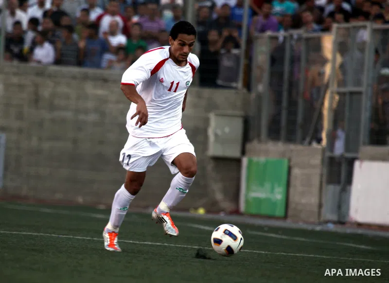 Palestinian team player kicks the ball in the match between his national team and Bahrain's team during their 2012 Olympic qualifying football match in the West Bank town of Al-Ram, near Ramallah, on June 23, 2011 . Phot...