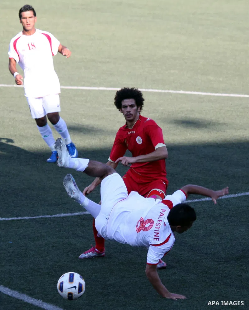 Palestinian team's player challenges the Bahrain's player during their 2012 Olympic qualifying football match in the West Bank town of Al-Ram, near Ramallah, on June 23, 2011 . Photo by Issam Rimawi
