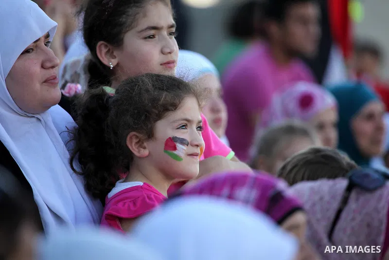 Palestinian fans attend a football match between their national team and Bahrain team during their 2012 Olympic qualifying football match in the West Bank town of Al-Ram, near Ramallah, on June 23, 2011. Photo by Issam R...