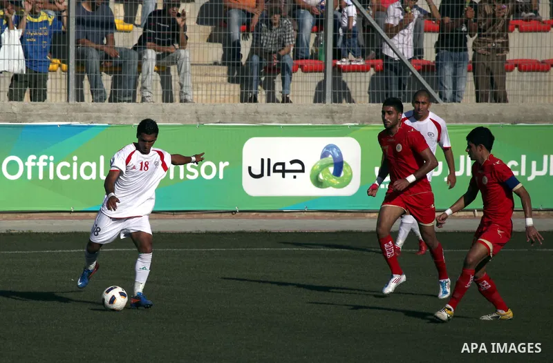 Palestinian team's player challenges the Bahrain's player during their 2012 Olympic qualifying football match in the West Bank town of Al-Ram, near Ramallah, on June 23, 2011 . Photo by Issam Rimawi