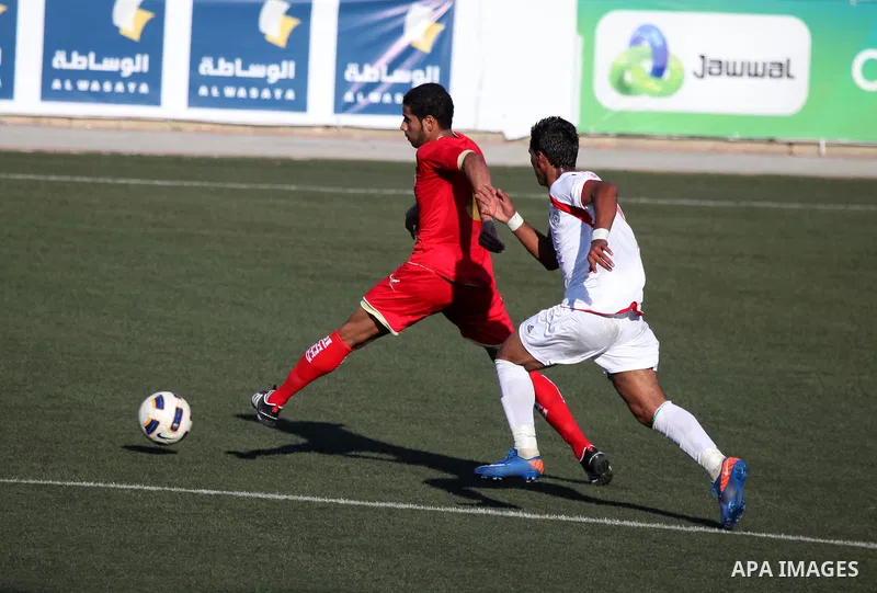 Palestinian team's player challenges the Bahrain's player during their 2012 Olympic qualifying football match in the West Bank town of Al-Ram, near Ramallah, on June 23, 2011 . Photo by Issam Rimawi
