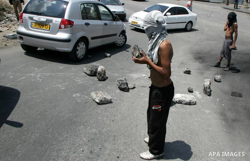 Masked Palestinian youths close the road with stones in front of the Israeli forces outside the protest tent in the east Jerusalem neighborhood of Silwan on June 24, 2011.. Photo by Mahfouz Abu Turk