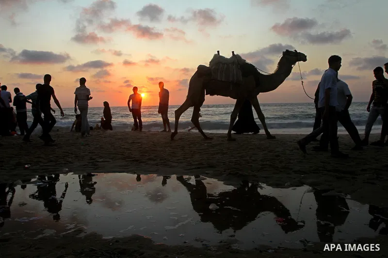 Palestinians walk along the beach in Gaza City on June 24, 2011. Photo by Ashraf Amra