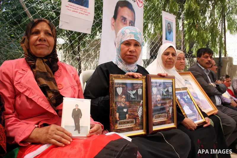 Palestinians hold pictures of relatives jailed in Israel during a protest against Israeli Prime Minister Benjamin Netanyahu's decision to worsen the prisoners holding conditions on Jun 26,2011, outside the International...