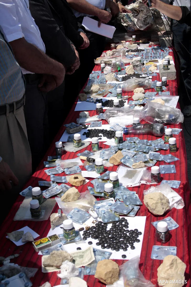 Palestinian police officers display the confiscated drugs which include heroin, opium and marijuana during a campaign against illegal drugs in the West Bank city of Hebron, 26 June 2011. Photo by Najeh Hashlamoun ..