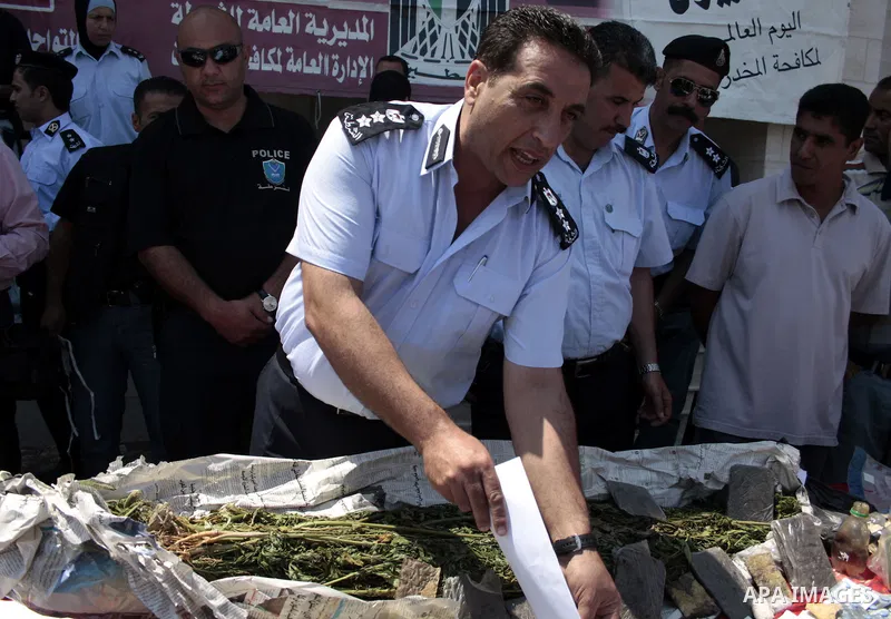 Palestinian police officers display the confiscated drugs which include heroin, opium and marijuana during a campaign against illegal drugs in the West Bank city of Hebron, 26 June 2011. Photo by Najeh Hashlamoun ..