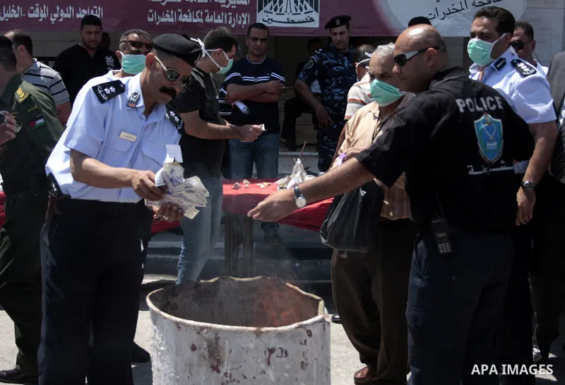 Palestinian police officers burn the confiscated drugs which include heroin, opium and marijuana during a campaign against illegal drugs in the West Bank city of Hebron, 26 June 2011. Photo by Najeh Hashlamoun ..
