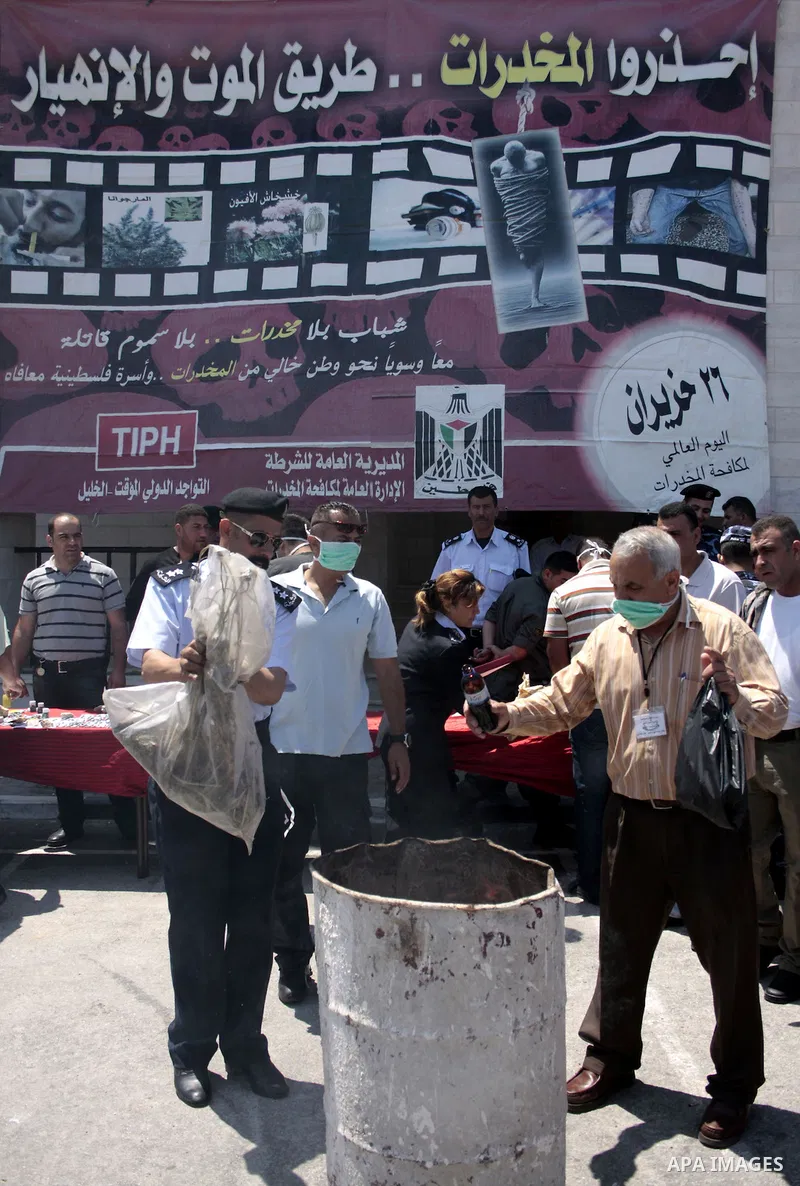 Palestinian police officers burn the confiscated drugs which include heroin, opium and marijuana during a campaign against illegal drugs in the West Bank city of Hebron, 26 June 2011. Photo by Najeh Hashlamoun ..