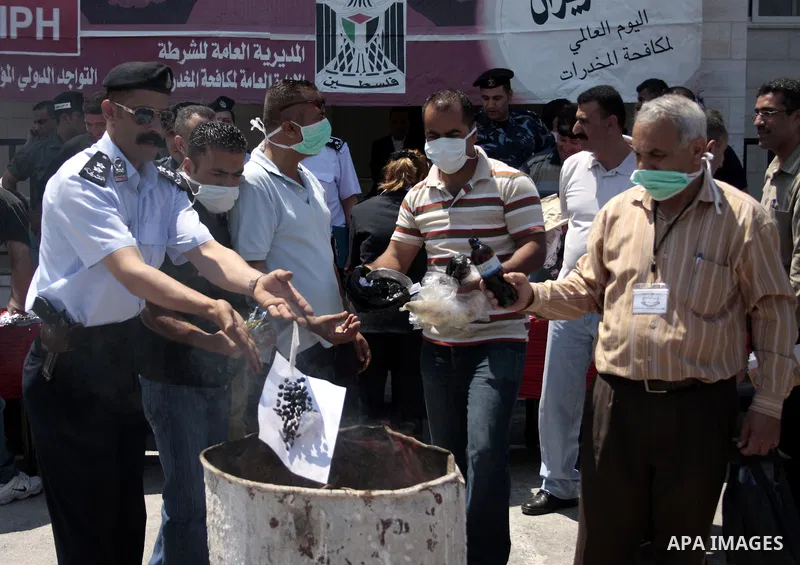 Palestinian police officers burn the confiscated drugs which include heroin, opium and marijuana during a campaign against illegal drugs in the West Bank city of Hebron, 26 June 2011. Photo by Najeh Hashlamoun ..