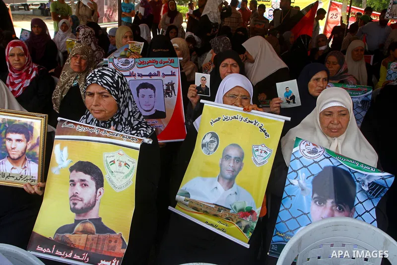 Palestinian women hold pictures of relatives during a protest calling for the release of Palestinian prisoners from Israeli jails in front of the Red Cross in Gaza city on June 26, 2011. Photo by Ashraf Amra