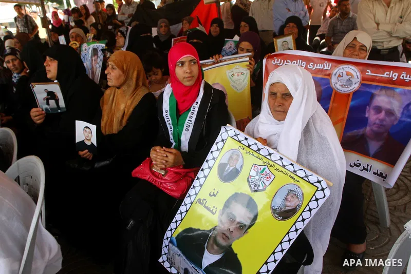 Palestinian women hold pictures of relatives during a protest calling for the release of Palestinian prisoners from Israeli jails in front of the Red Cross in Gaza city on June 26, 2011. Photo by Ashraf Amra