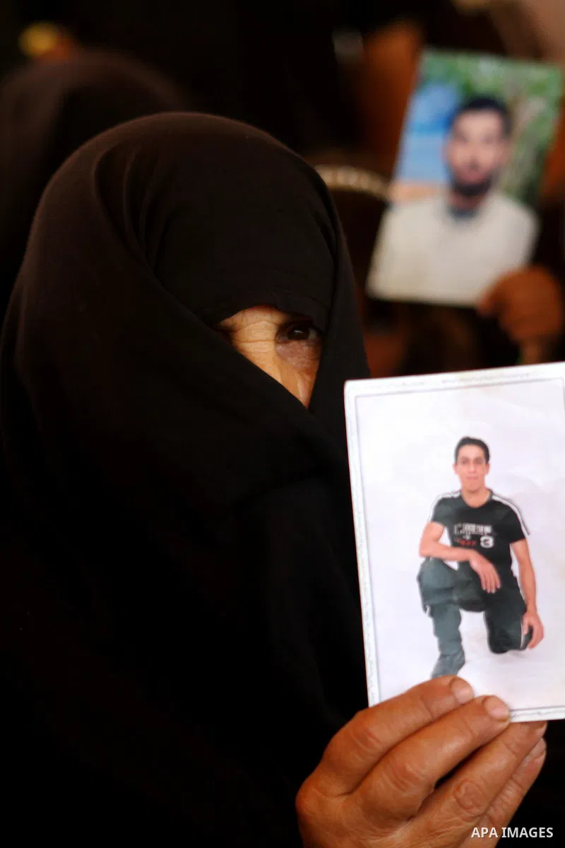 A Palestinian woman holds pictures of relatives during a protest calling for the release of Palestinian prisoners from Israeli jails in front of the Red Cross in Gaza city on June 26, 2011. Photo by Ashraf Amra