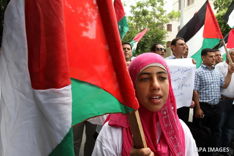 Palestinians from NGOs hold national flags during a protest in solidarity with freedom flotilla "2" and to break the seige in front of the UNRWA headquarters in Gaza city on June 27, 2011. Photo by Mohammed Asad