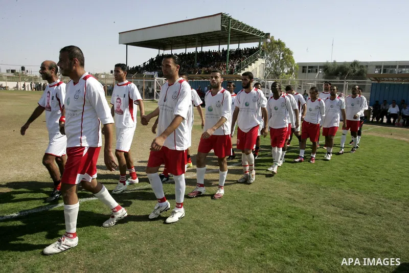 Palestinian football players prepare for a football match between Khan Yunis Youth club (red shirt) and Rafah Collective club (white shirt) on Jun 27, 2011 in the southern Gaza Strip town of Rafah. Photo by Abed Rahim Kh...