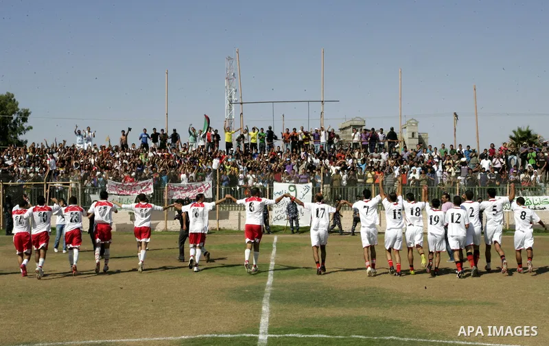 Palestinian football players prepare for a football match between Khan Yunis Youth club (red shirt) and Rafah Collective club (white shirt) on Jun 27, 2011 in the southern Gaza Strip town of Rafah. Photo by Abed Rahim Kh...