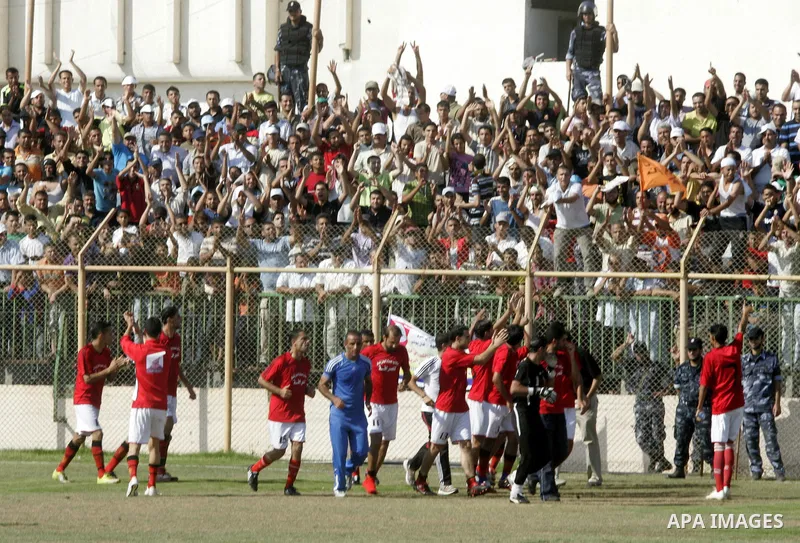 Palestinian football players prepare for a football match between Khan Yunis Youth club (red shirt) and Rafah Collective club (white shirt) on Jun 27, 2011 in the southern Gaza Strip town of Rafah. Photo by Abed Rahim Kh...