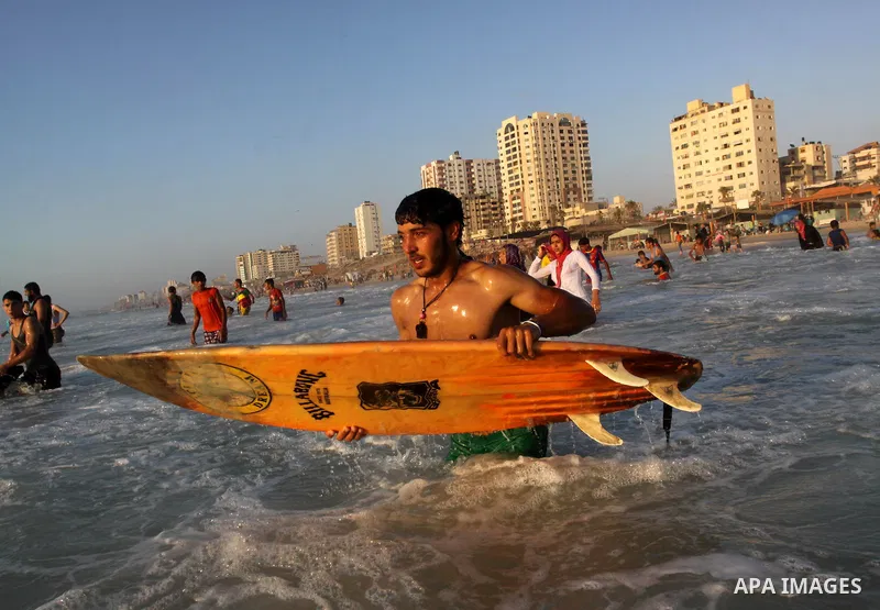 A Palestinian surfer rides a wave in Gaza City on Jun 28,2011. Photo by Mohammed Asad
