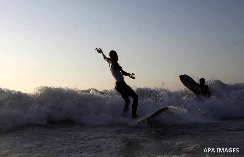 A Palestinian surfer rides a wave in Gaza City on Jun 28,2011. Photo by Mohammed Asad