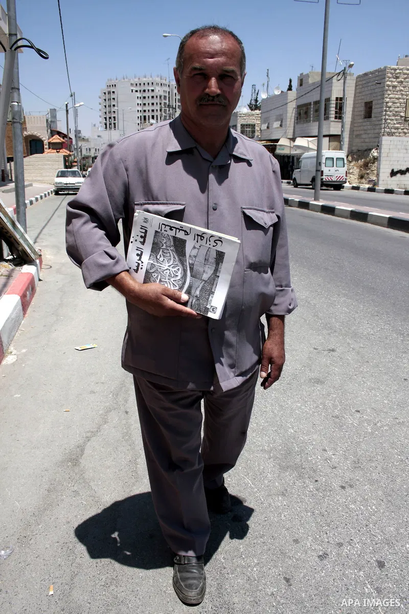 A Palestinian elderly man Elias Abdel-Hay holds a book as he prepare to study in the high school "Twajihi" after he left studing for 47 years old in the West Bank city of Hebron on June 29, 2011. Where he completed the n...