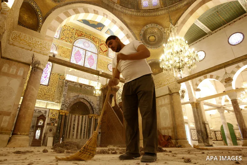 A Palestinian man cleans the floor inside the Al-Aqsa Mosque in Jerrusalem's old city on June 29, 2011 to prepare it for the fitting of a new carpet. According to Sheikh Azzam Khatib, the head of the Islamic Waqf in Jeru...