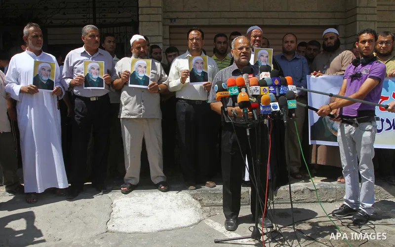 Supporters of Sheikh Raed Salah (portrait), head of the radical wing of the Islamic Movement in Israel, resport a speech during a demonstrate in Gaza City on June 30, 2011 after the controversial Arab-Israeli Islamist le...