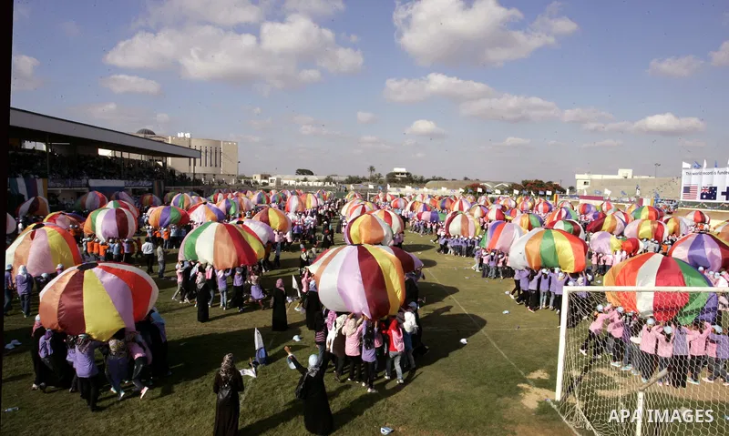 Palestinian children perform with coloured parachutes during summer camp activities supervised by the UN Relief and Works Agency (UNRWA) in Khan Yunis in the southern Gaza Strip on June 30, 2011. Photo by Abed Rahim Khat...