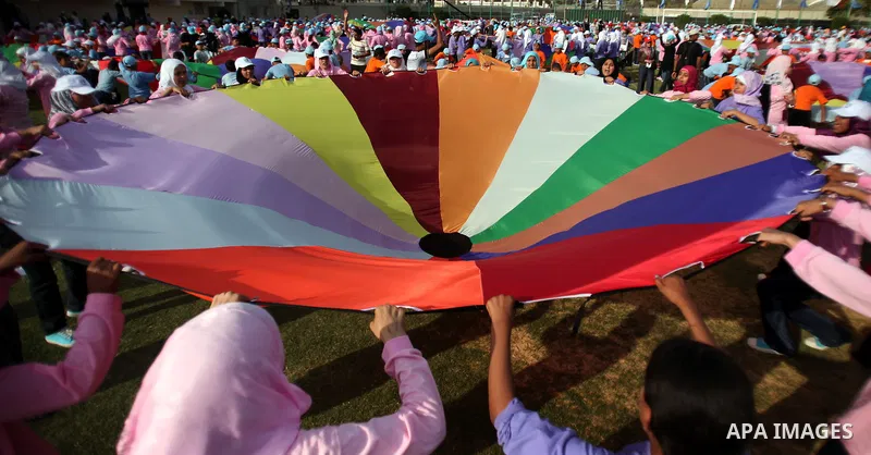 Palestinian children perform with coloured parachutes during summer camp activities supervised by the UN Relief and Works Agency (UNRWA) in Khan Yunis in the southern Gaza Strip on June 30, 2011. Photo by Ali Jadallah
