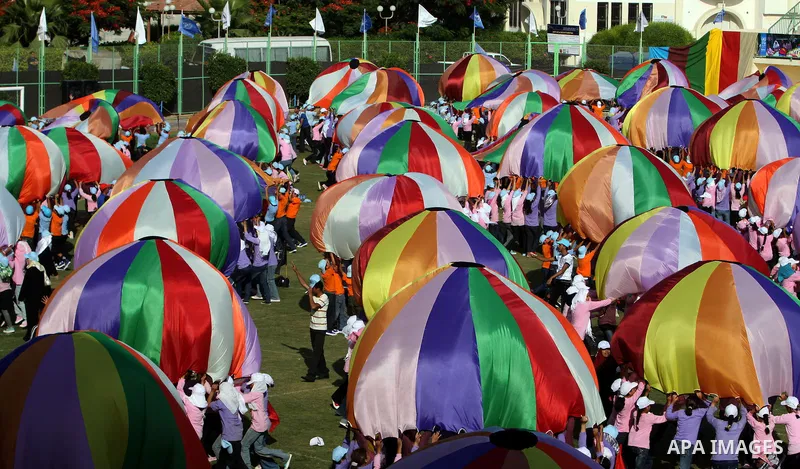 Palestinian children perform with coloured parachutes during summer camp activities supervised by the UN Relief and Works Agency (UNRWA) in Khan Yunis in the southern Gaza Strip on June 30, 2011. Photo by Ali Jadallah