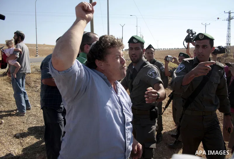 Israeli soldiers and an Israeli settler argue as security forces evacuate a group of Jewish settlers who tried to make a sit-in on a Palestinian land that was being cultivated by Palestinian farmers, on July 1, 2011 in t...