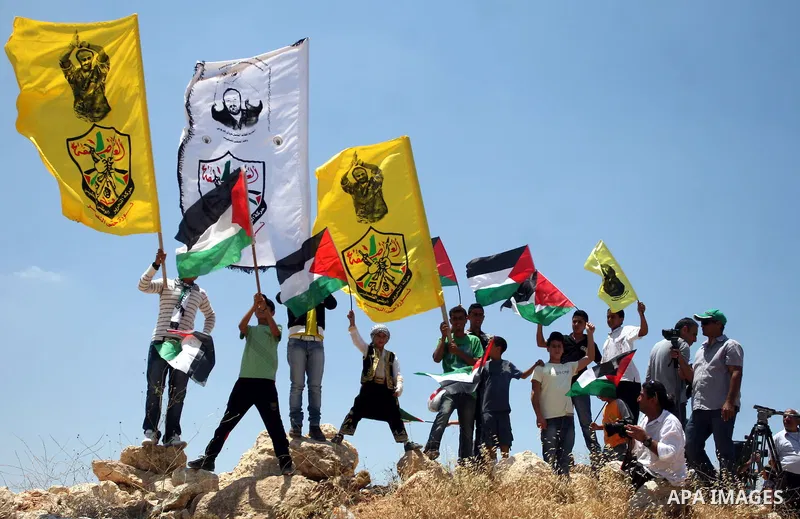 Palestinian demonstrators celebrate at the site where Israeli forces ripped down part of its controversial separation barrier outside the West Bank village of Bilin, the focus of anti-barrier protests, on July 1, 2011. I...